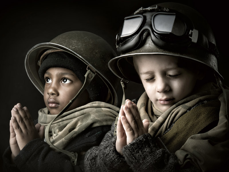 Picture of Two Young Children, dressed as Soldiers with hands together as if in prayer.