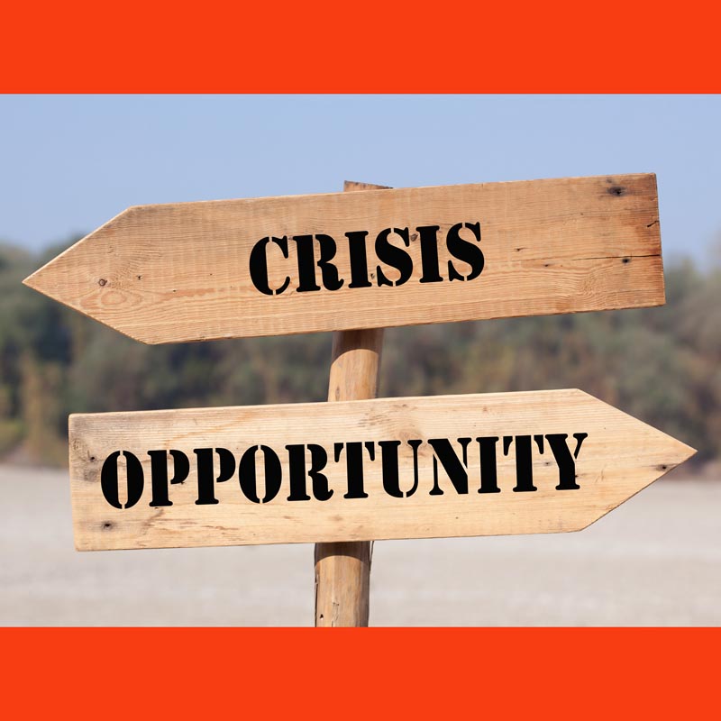 Road Sign with the words Crisis and Opportunity pointing in opposite directions