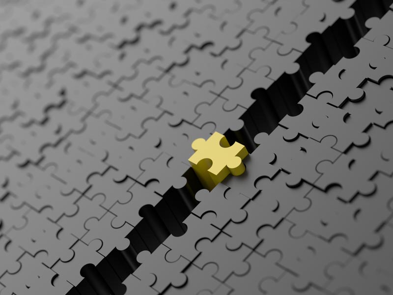 Image of a yellow puzzle piece bridging a gap between black puzzle pieces