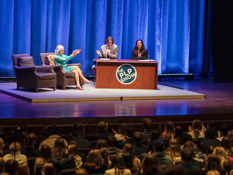 Photo of Cynthia Cherrey on stage at Christopher Newport University with the two hosts of the PLP Show